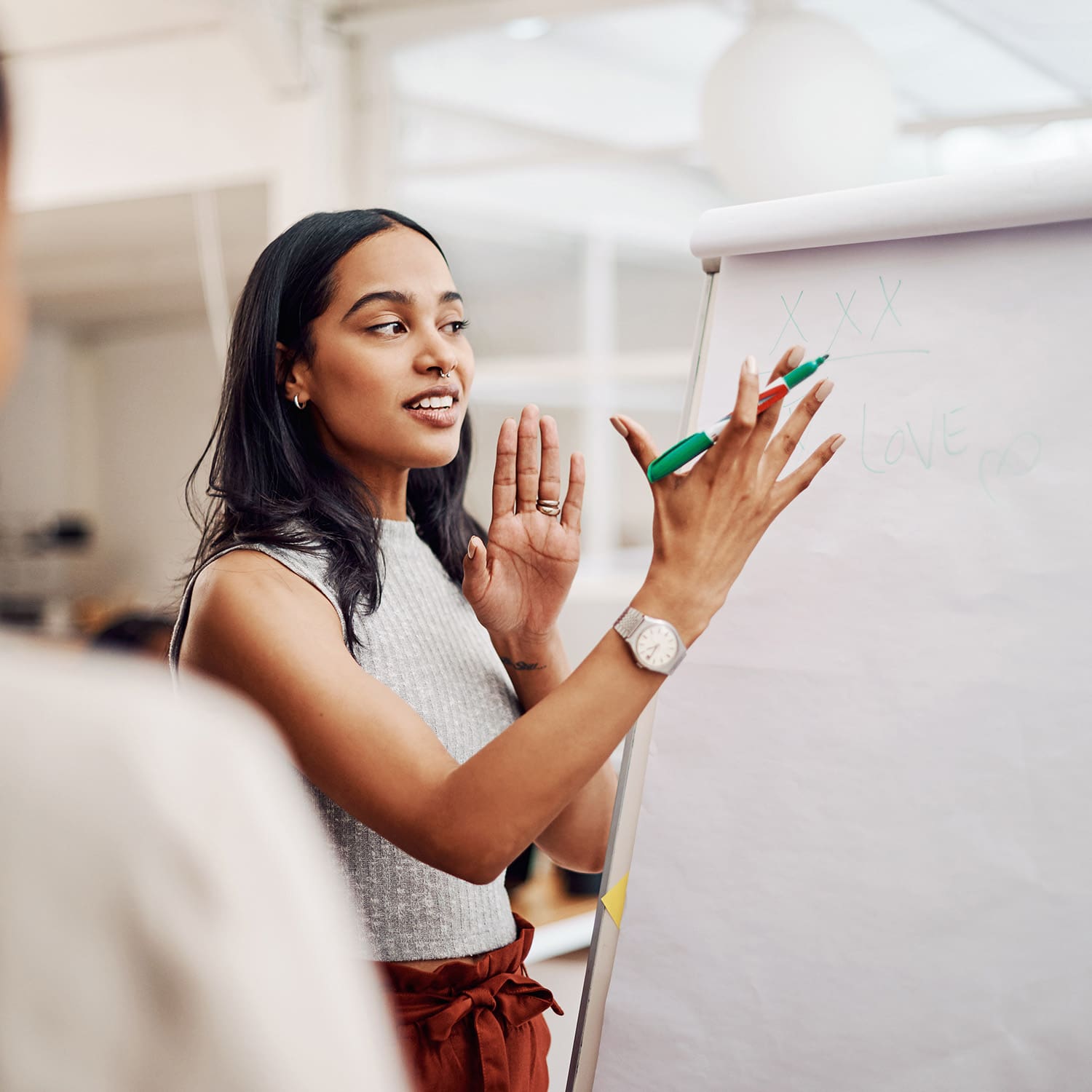 Woman, mentor and whiteboard in office for training, teaching and learning for skill or career development. People, employee and coach or leader at workshop with internship program and motivation.